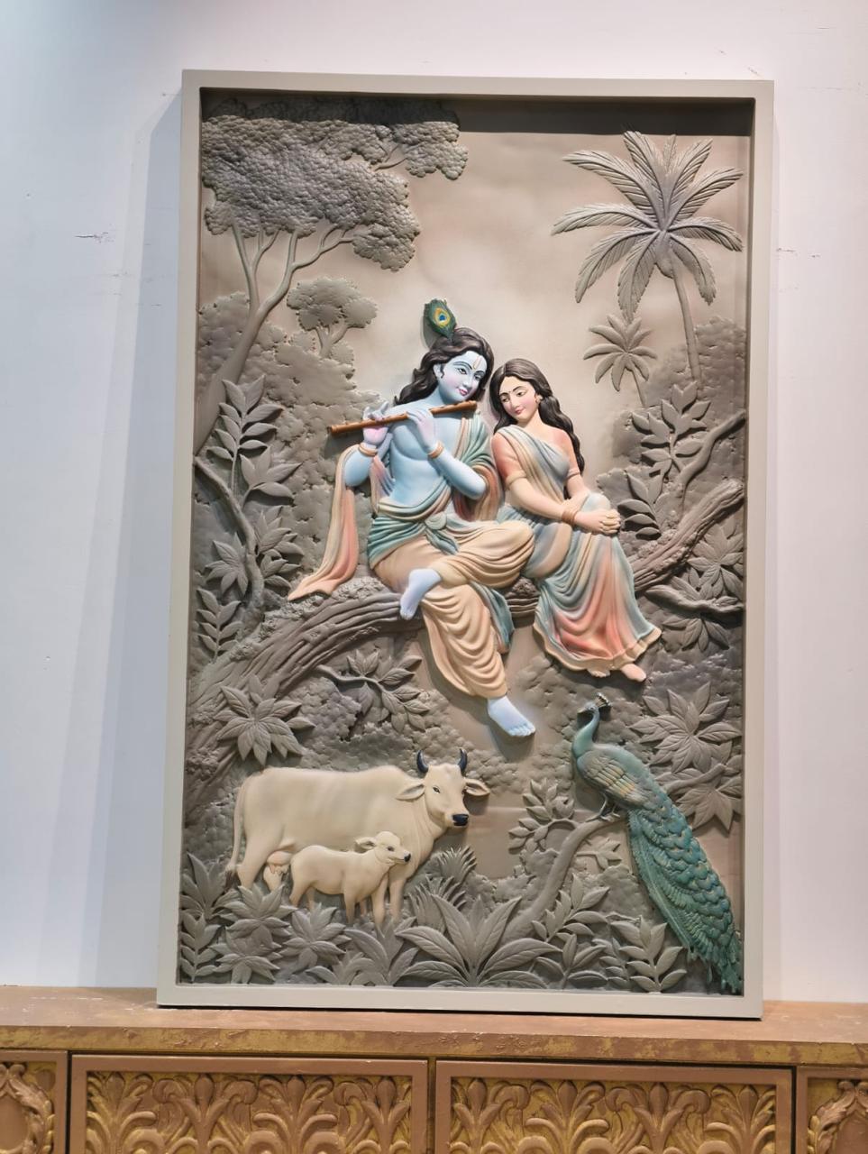 Relief of Radha and Krishna in a forest with a cow and a peacock